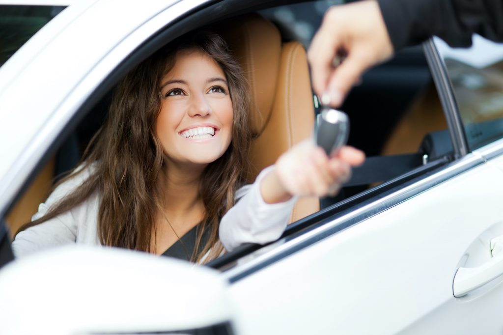 Young,Woman,Receiving,The,Keys,Of,Her,New,Car